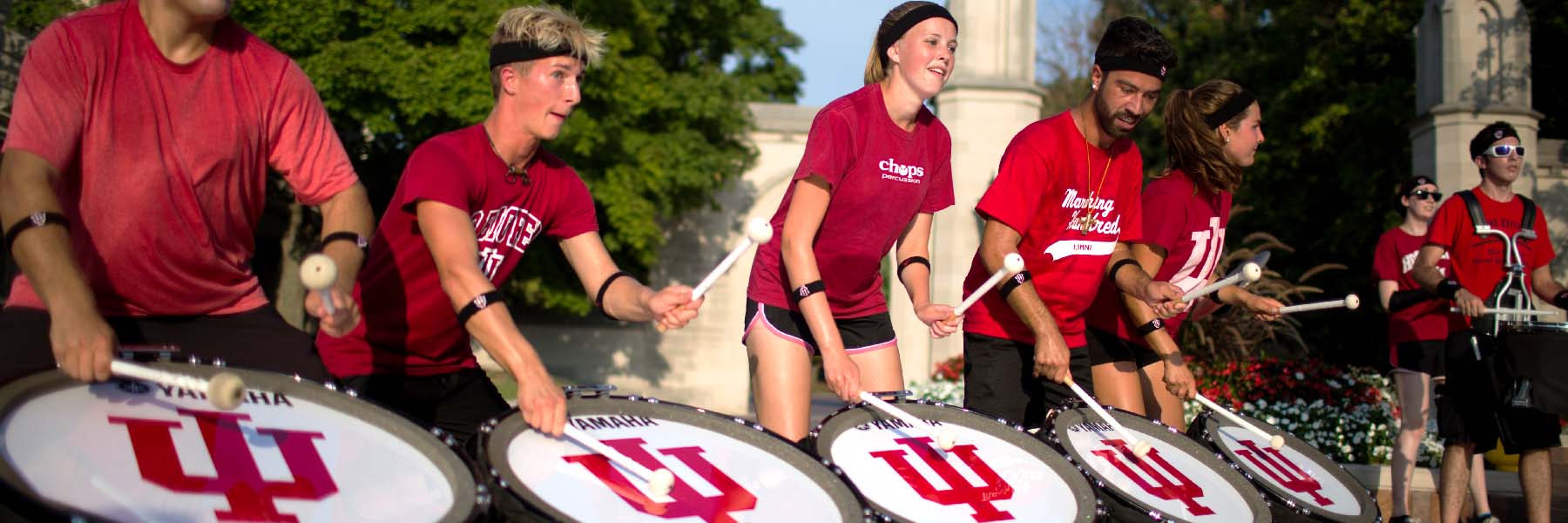 Members of the Marching Hundred play drums on a sunny day.