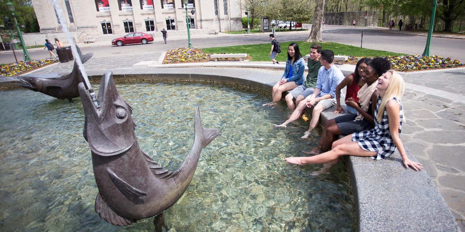 Students dunk their feet in Showalter Fountain.